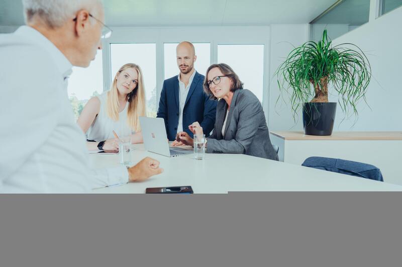 Gruppe von DCCS Mitarbeitern an Stehtisch